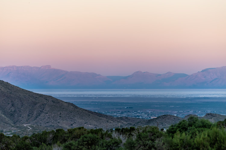 View of the town of La Luz, New Mexico, and the nearby Organ Mountains and White Sands National Park at twilight. 