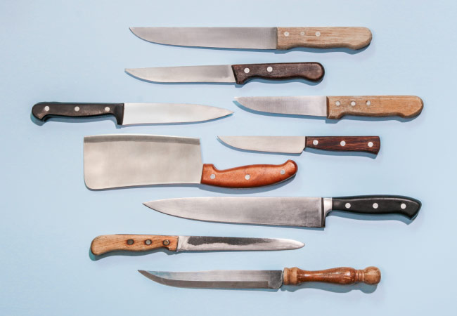 A set of sharp kitchen knives are neatly arranged against a light blue background.