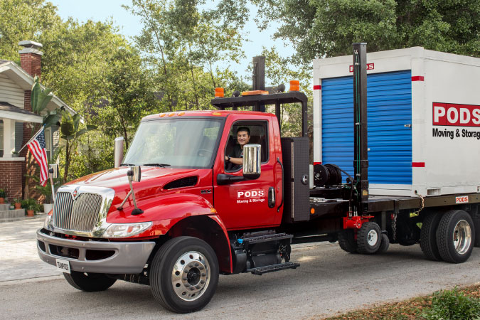 A PODS truck is loaded up with a PODS moving container, ready to transport it for a partial DITY move.