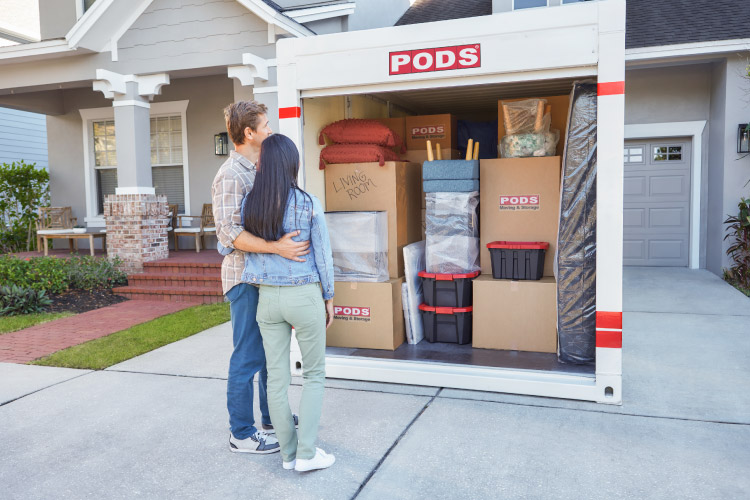 A couple is preparing for retirement in Arizona and have just finished loading the PODS portable moving container that is located in their driveway.