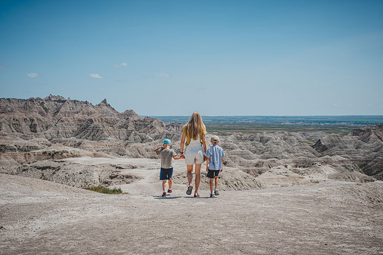 A mother and her two sons hike the Badlands National Park