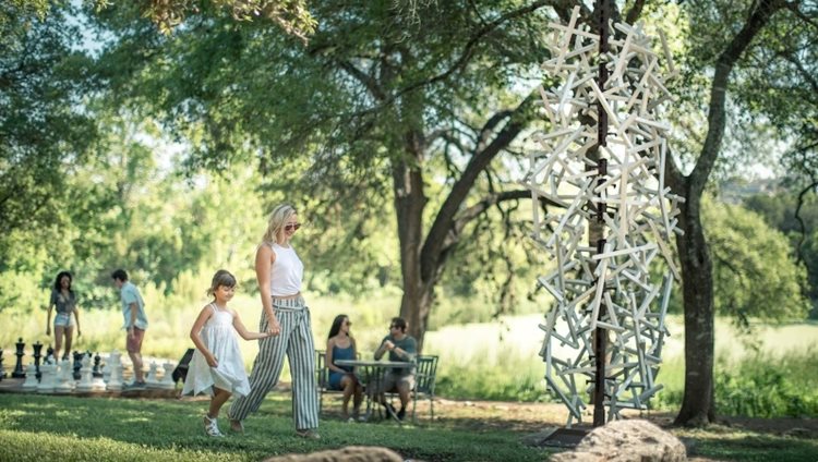 A young mother and her daughter explore Bee Cave Sculpture Park on a sunny day in Bee Cave, Texas.