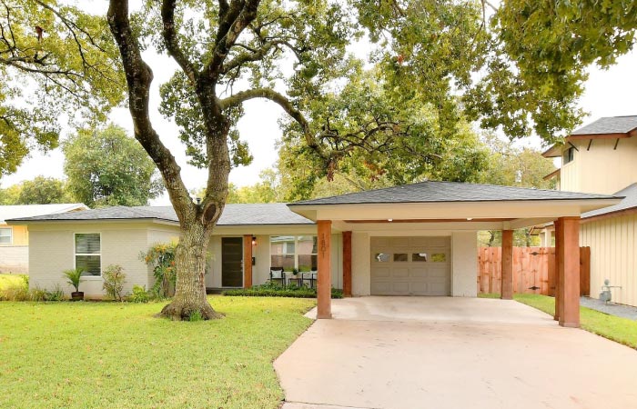 A one-story, three-bedroom home in the Crestview neighborhood of Austin, Texas. The home features a one-car garage and attached carport.