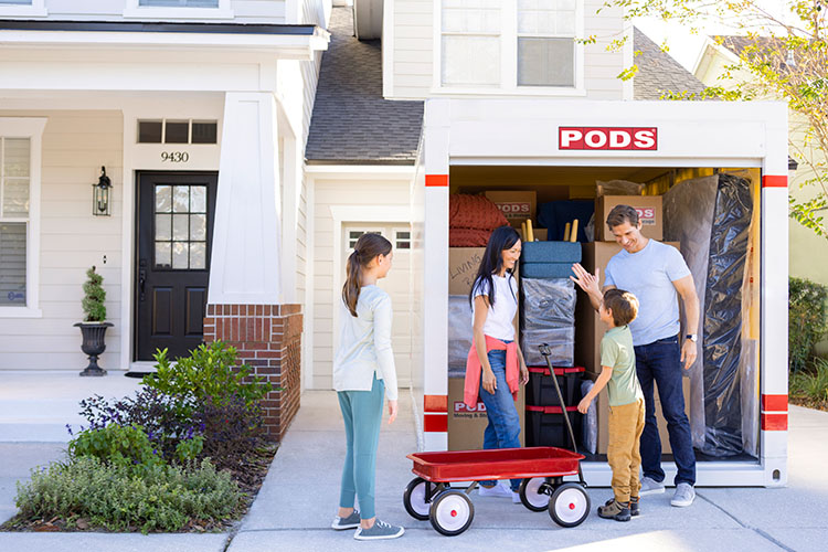 A family of four loading up their PODS container to move to their new home state. 