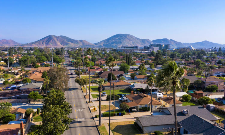 Aerial view of the city of Fontana, California, and the surrounding mountains on a clear summer day.