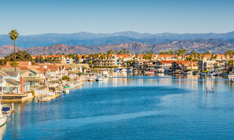 View of large waterfront houses in Oxnard, California, with the mountains in the distance. 
