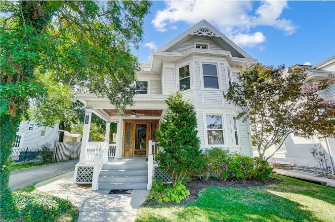 A Victorian-style home in the Hyde Park neighborhood of Cincinnati, featuring a light exterior and natural wood front door.