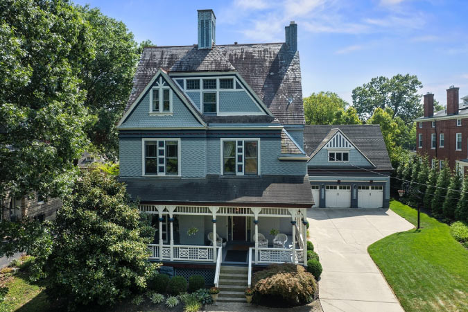 A multilevel Victorian-style home in Cincinnati’s East Walnut Hills neighborhood, featuring a large three-car garage in the back