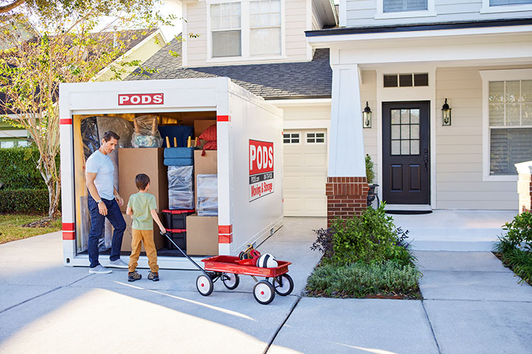  A father and son load up a PODS container in their driveway as they get ready for their move to one of the best cities near Austin.