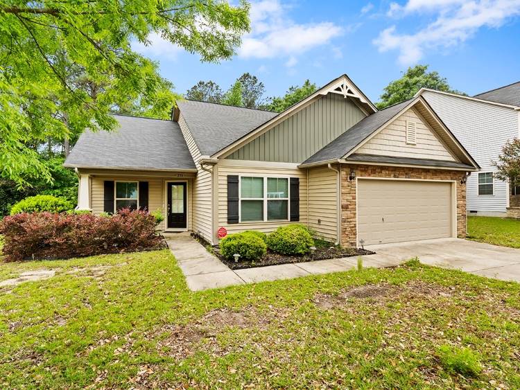 A single-family home in Cayce, SC. Leaves are scattered across the lawn, and the driveway has been recently blown. 