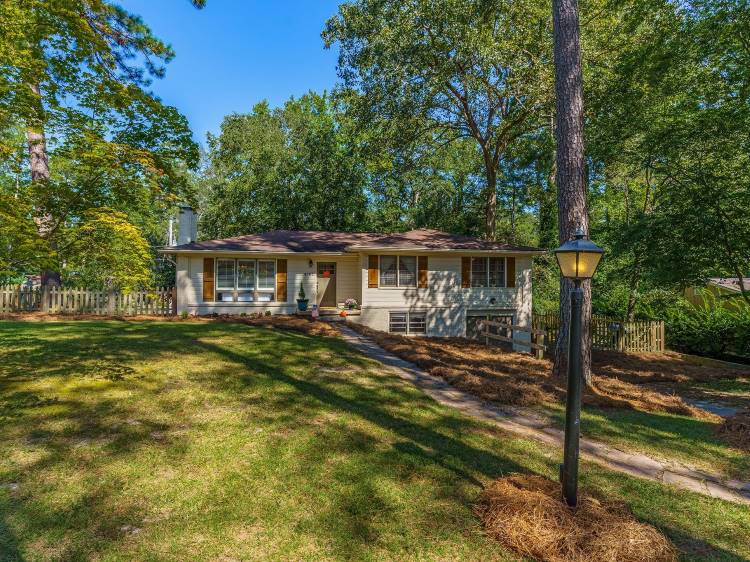 shady single-family home in Forest Acres, SC. There is a long driveway leading up to the door, and the lawn is impressively large. 