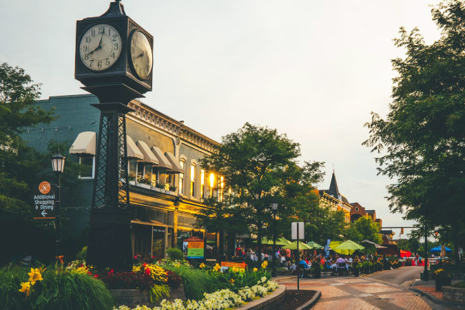 Sunset view of the four-faced clock tower and surrounding buildings in Downtown Northville, Michigan