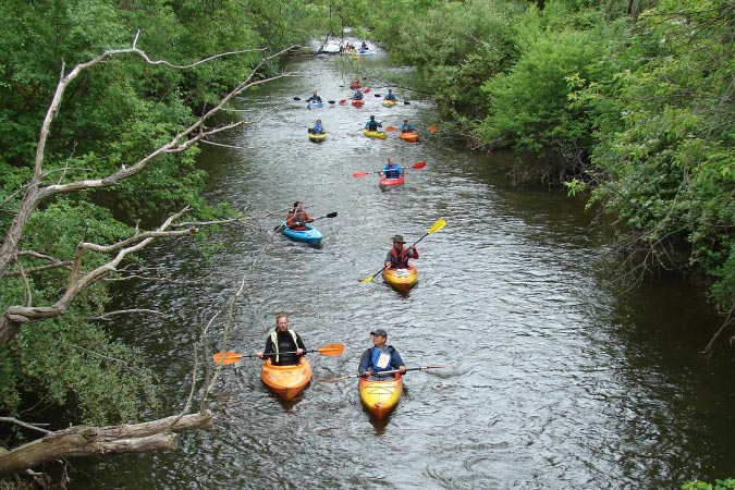 A group of locals are kayaking down the Clinton River in Rochester Hills, Michigan.