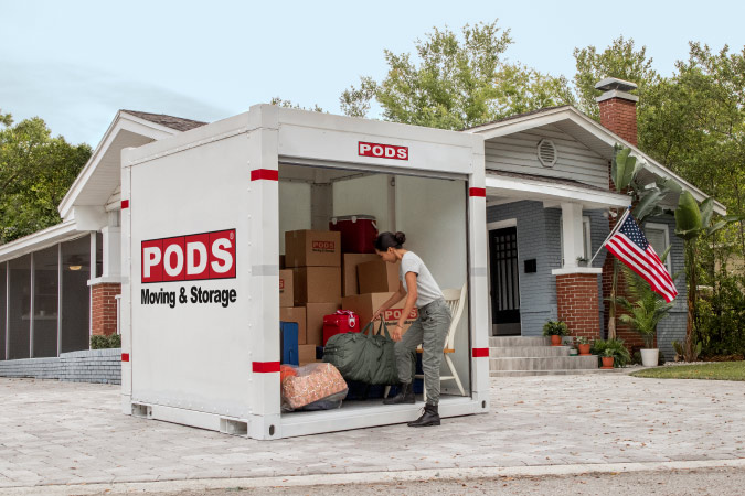 A soldier is loading the final bag in her ӰPro portable moving and storage container during her DITY move.