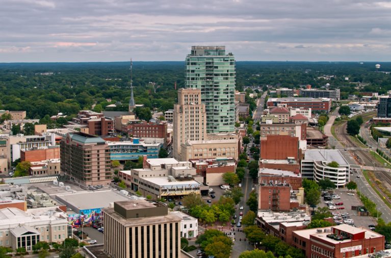 Aerial view of Durham, North Carolina, with surrounding neighborhoods and woodlands.