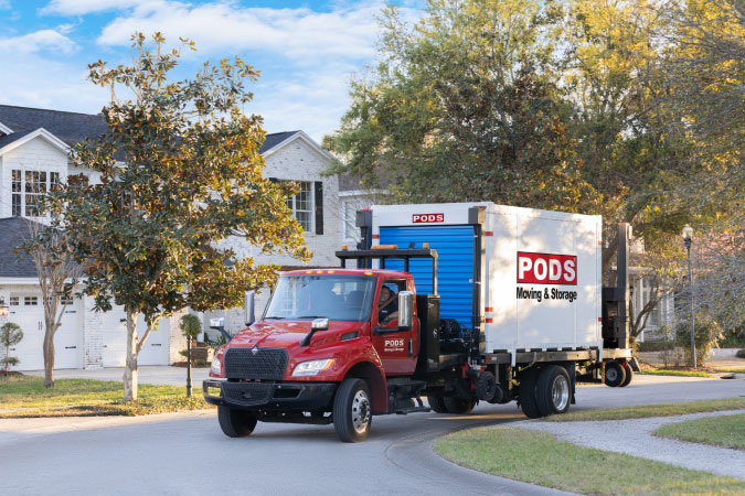 A truck is transporting a PODS portable moving and storage container through one of the best Durham neighborhoods.