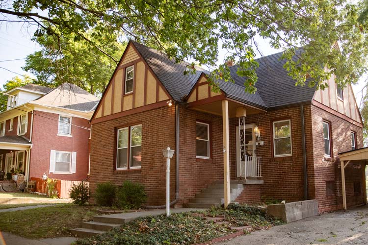A multi-family brick home in Atchison, Kansas, with Tudor detailing in the gable ends. 
