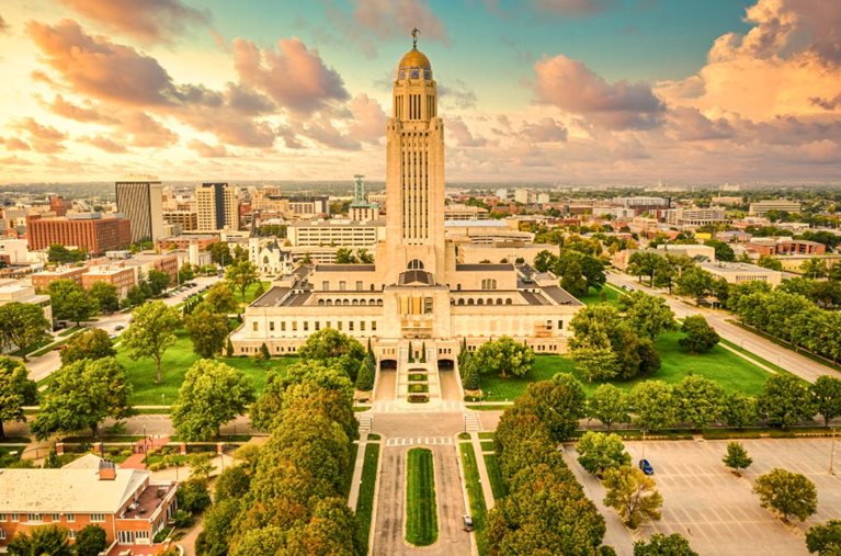 Sunrise view of the Nebraska State Capitol and surrounding cityscape in Lincoln, Nebraska.