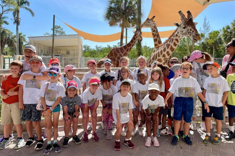 Students from a Collier County public school in Naples, Florida, pose for a picture with giraffes during a field trip to the zoo.