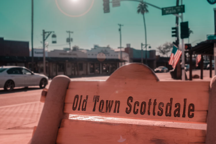 Close-up view of a wooden bench with the words “Old Town Scottsdale” engraved on the back in the Old Town Scottsdale neighborhood of Scottsdale, Arizona. 