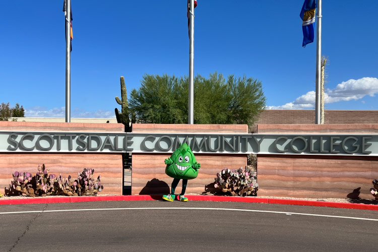 The Scottsdale Community College mascot poses for a photo in front of the school’s entrance sign.