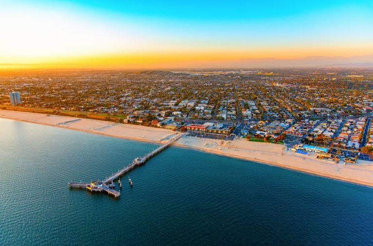 Sunset aerial view of the coast in Long Beach, California, featuring the Belmont Veterans Memorial Pier.