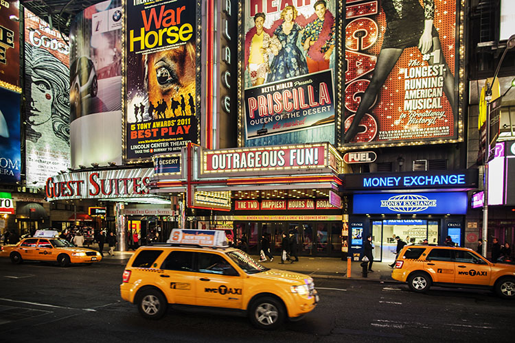 Broadway theaters at night. The bright lights and bustling cars give the area an exciting energy