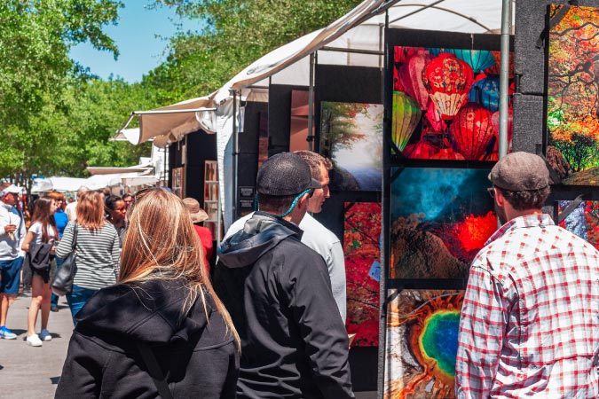 Locals tour tents filled with local art at an art festival in The Woodlands, Texas.