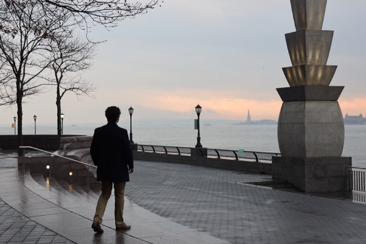 A man is taking a sunset stroll in a park in Battery Park City, Manhattan, after the rain.