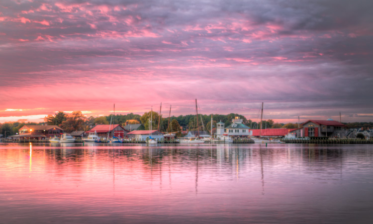 The waterfront buildings are highlighted by a purple-tinted sunset in the harbor of St. Michaels, Maryland