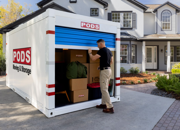 A military serviceman is closing the door on his loaded PODS container during his PPM.