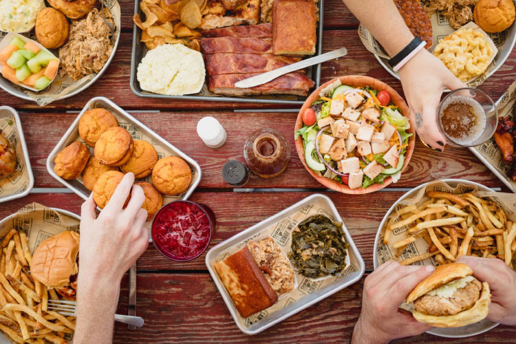 View from above of a group of friends enjoying a delicious spread from Skylight Inn BBQ in Ayden, North Carolina.