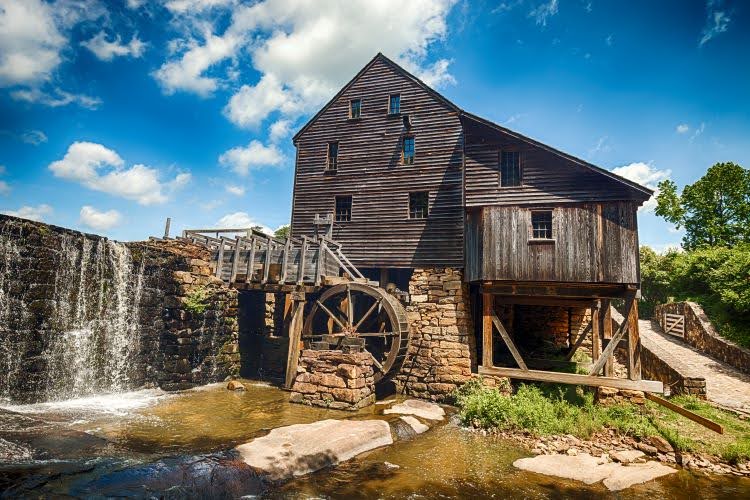 An old mill in Yates Park outside Raleigh, NC. A water wheel turns and lets the mill grind foodstuffs like corn, wheat, and other grains.