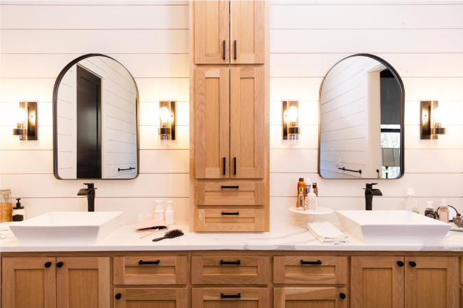 A beautifully decluttered bathroom counter with twin mirrors and sinks