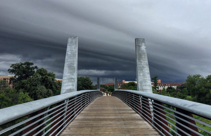 A dark, cloudy sky above a bridge in Houston, Texas, signals an incoming storm.