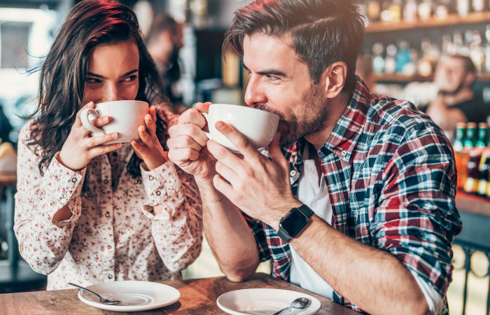 A happy couple is sipping coffee together at a cafe in Houston, Texas.