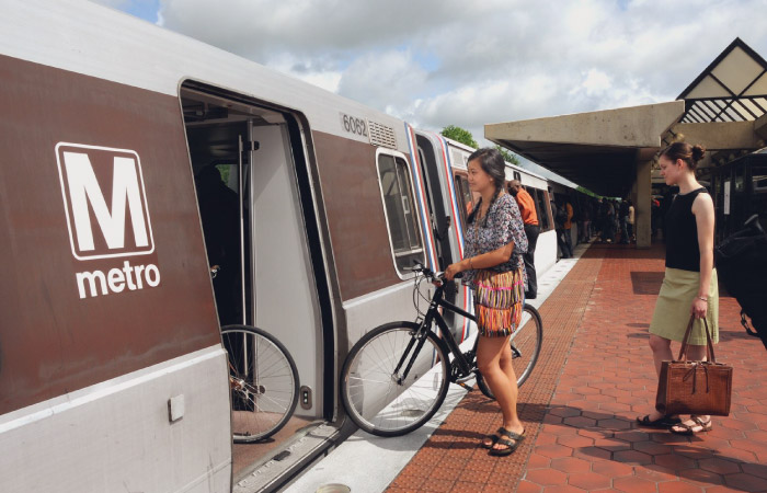 A woman with a bicycle is about to board a metro train in Washington, D.C.