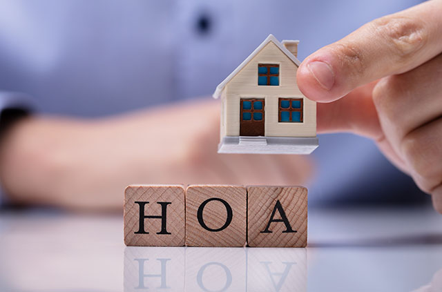 Three blocks that read “HOA” with a wooden model house