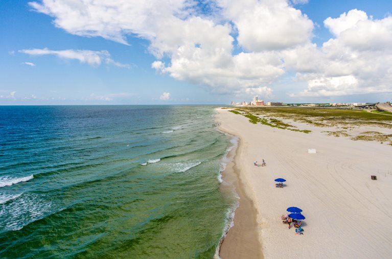 A few locals enjoy the beach to themselves in Orange Beach, Louisiana. It’s a sunny day and the water is as vibrant and clear as the sand is fine and soft.