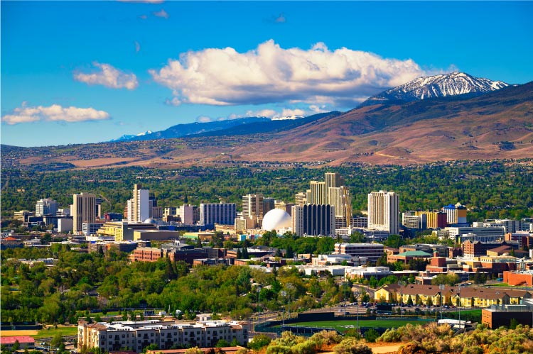 Aerial view of the Downtown Reno skyline. The lush green of the city is a stark contrast to the surrounding High Eastern Sierra foothills. 