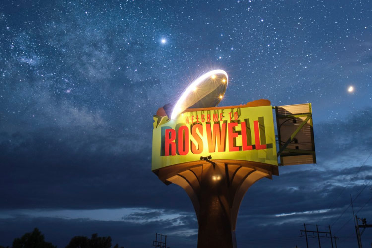 The illuminated “Welcome to Roswell” sign in Roswell, New Mexico, seen against a starry sky.