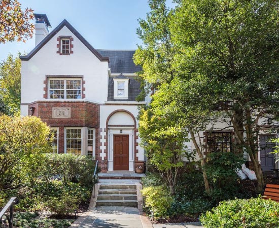 A beautiful brick home in D.C.’s Cleveland Park neighborhood, featuring a lush front yard.