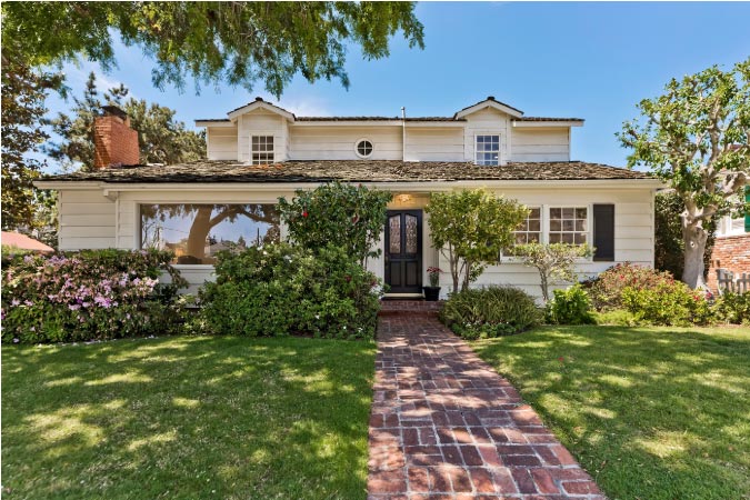 A luxurious two-story home in Beverlywood, featuring a flagstone walkway and lush front yard.