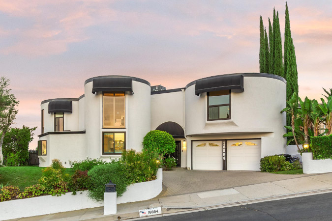 Exterior view of an art deco home in Encino — one of the safest neighborhoods in Los Angeles — built on a sloped residential street.