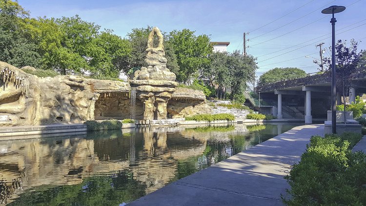 A stone structure by a river leading to the Tobin Hill neighborhood in San Antonio