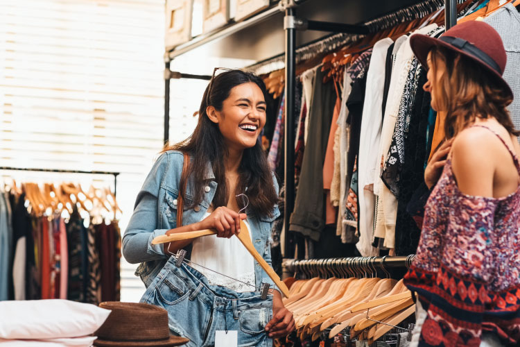 Two women are laughing as they shop in a boutique clothing store in Sierra Vista, Arizona