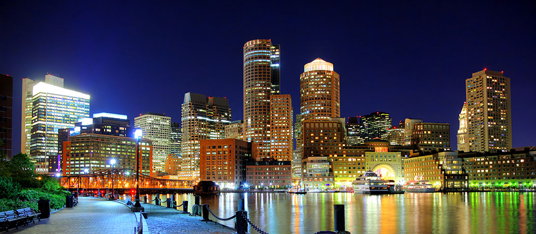 The city of Boston at night as seen from the harbor