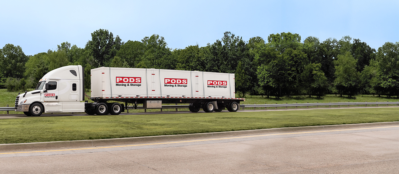 A truck carrying three PODS containers as part of a long-distance move