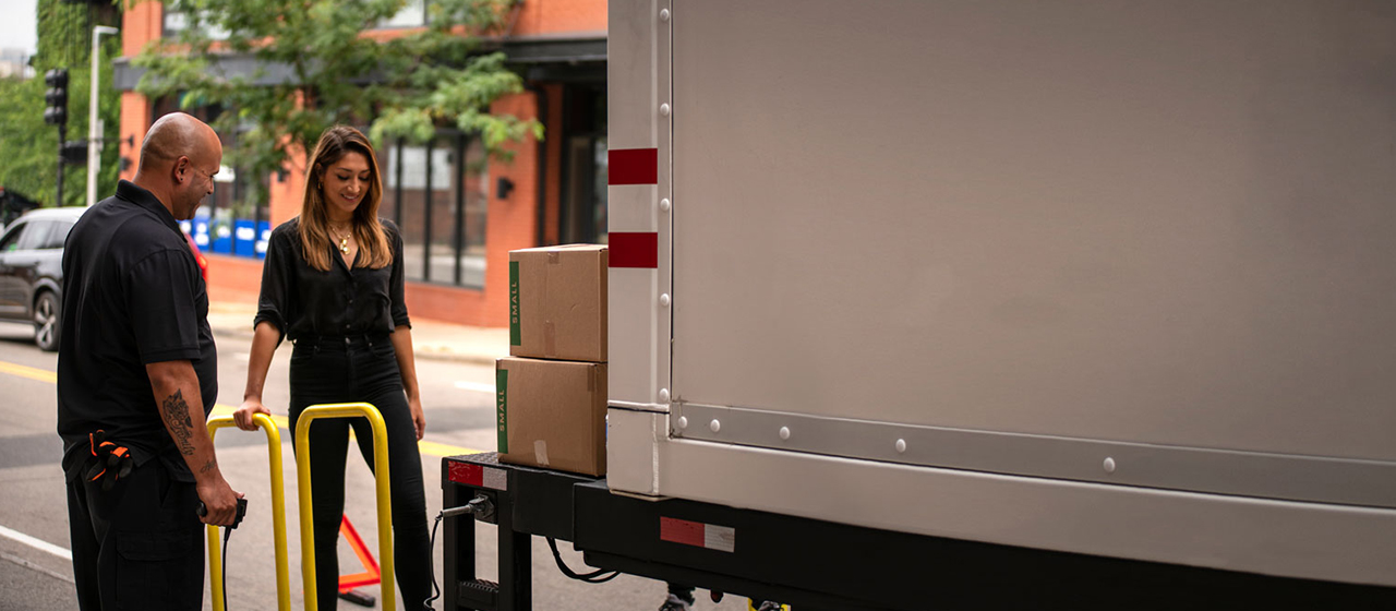 Two people loading up a PODS container on a city street