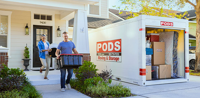 People packing PODS container in driveway